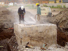 Workers drilling holes for Bustar expansive grout. Workers drilling holes for Bustar expansive grout.